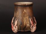 a brown vase with two hands on it