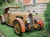 une vieille voiture garée sur la pelouse devant un immeuble