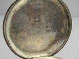 a close up of a silver pocket watch on a white surface