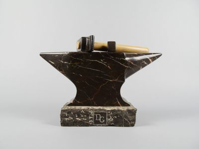 marble anvil with a hammer on top of it on a white background