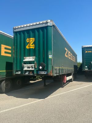 two green semi trucks that are parked next to each other