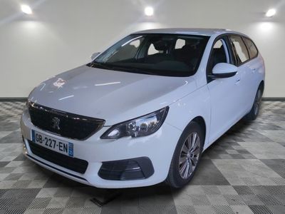la voiture blanche est garée sur un sol en damier dans le garage