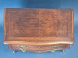 an image of a wooden chest of drawers sitting on top of a blue carpet