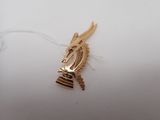 an image of a close up of a gold broochle on a white surface