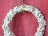 a wreath hanging on a chain on a red cloth