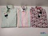 three men ' s shirts are lined up on a white table