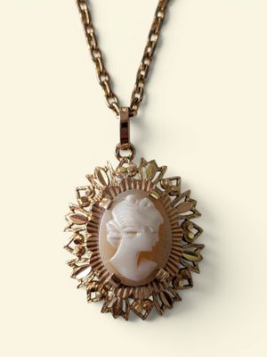 un gros plan d'un collier orné du visage d'une femme