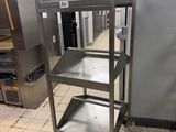 a metal cart that is sitting in the middle of a kitchen
