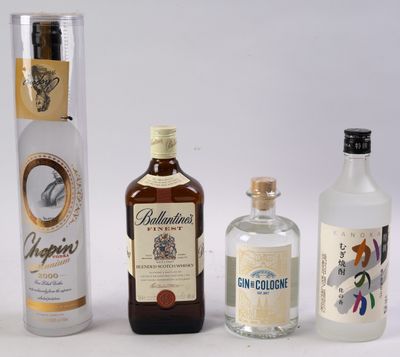 trois bouteilles d'alcool sont alignées sur une surface blanche
