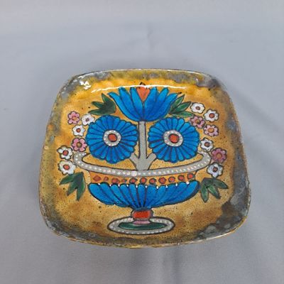 une assiette bleue et jaune décorée de fleurs