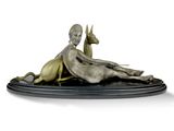une statue en bronze représentant une femme allongée sur le ventre avec un chien