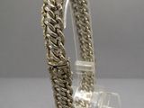 a close up of a silver bracelet on a clear stand