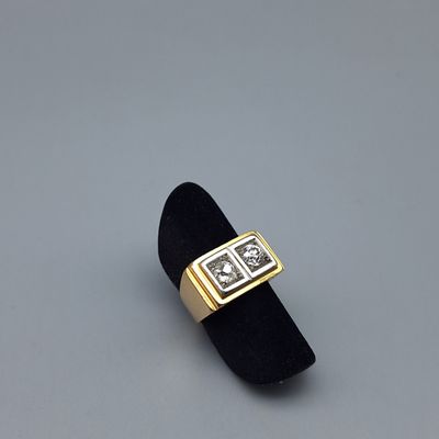 une photo d'une bague en or et diamants posée sur un présentoir en velours noir