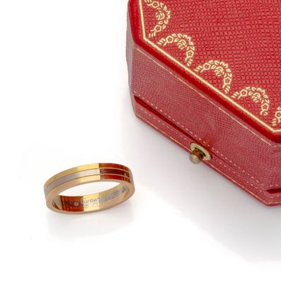 a red box and a gold ring on a white surface