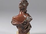 a bronze bust of a woman on a marble base