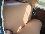 a seat in the back of a car that has a tan seat cover