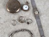 une montre, un bracelet, une bague et d'autres bijoux par terre