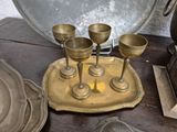 a gold tray with four wine glasses on it and a silver tray with four wine glasses on it