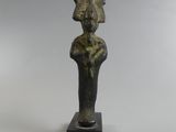 une statue en bronze représentant une femme coiffée d'une coiffe