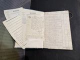un livre ouvert posé sur une table, à côté d'une pile de papiers