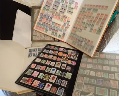 beaucoup de timbres posés sur une table, à côté d'un livre