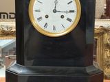 une horloge posée sur une table devant un miroir