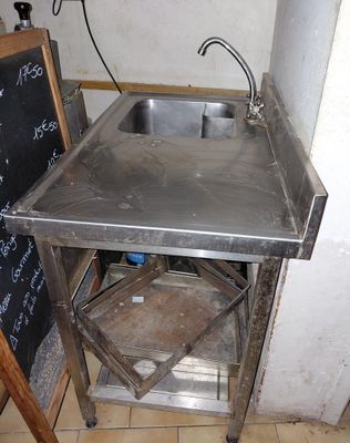 a sink and a chalk board in the corner of a room