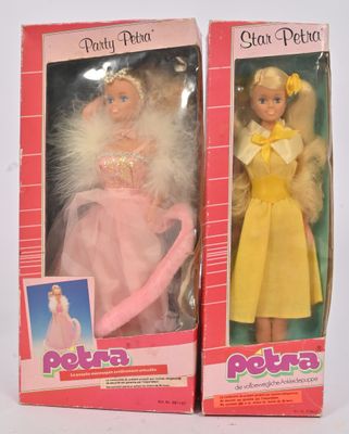 deux poupées dans leur boîte représentant une petite fille en robe jaune, une petite fille en robe rose et une petite fille en robe jaune
