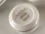 a jar of cream sitting on a table next to a plate
