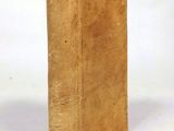an old book sitting on top of a white table next to a white wall