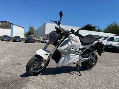 a white motorcycle parked in a parking lot next to a building