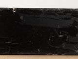 a black marble block sitting on a wooden table