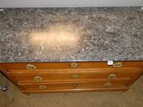 a marble top on a wooden dresser in a room