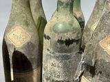 several bottles of wine are sitting on a table with a shadow