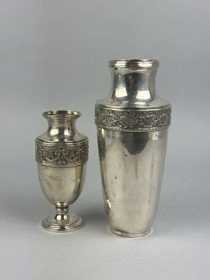 deux vases en argent posés l'un à côté de l'autre sur une table
