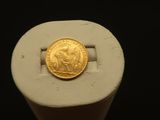 une image représentant une pièce d'or posée sur un objet blanc