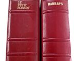 two red leather books sitting next to each other on a white surface