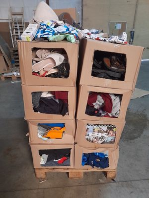 une pile de cartons sur lesquels sont posés des vêtements