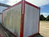 a red and white container sitting on the side of the road