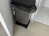 une poubelle dans un coin de la salle de bains, à côté d'une autre poubelle