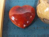 a heart shaped stone sitting on a table next to a candle