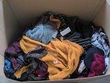a cardboard box full of clothes that is sitting on the floor