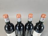 four bottles of wine are lined up in a row