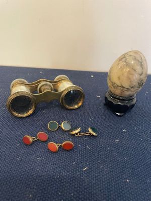 a pair of binoculars and a pair of earrings on a table