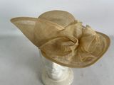 beige hat with a large flower on top of it on a mannequin headpiece