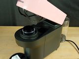 a pink and black blender sitting on a wooden table