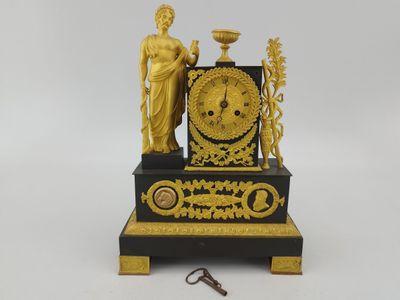 a gold and black clock with a statue on it