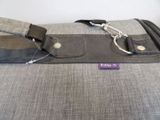 a gray bag with a purple tag attached to it