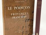 un vieux livre posé à côté d'un livre marron sur lequel figurent des inscriptions