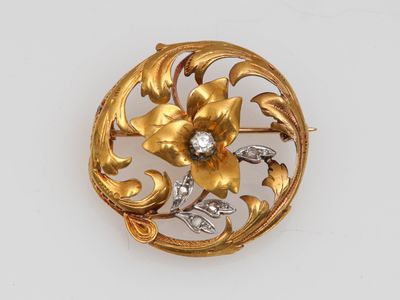 un gros plan d'une broche en or ornée d'un diamant au centre